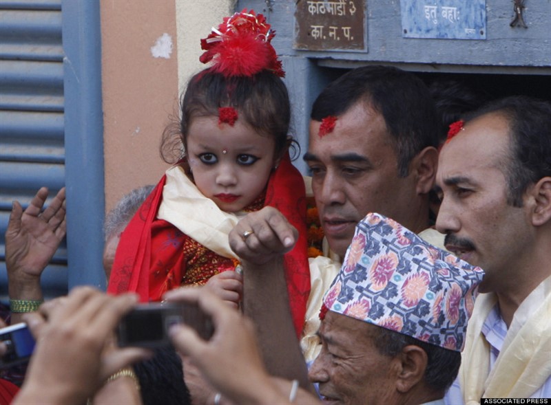 Kumárí bývají ve svém božství rozpoznané jako velmi mladé. Na snímku je tříletá Matani Shakya na své cestě do paláce. | http://www.huffingtonpost.com/