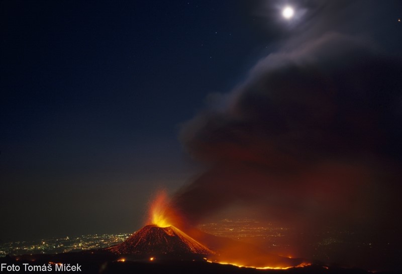 Etna 2011, boční kráter Montagnola, noční erupce s měsícem, v pozadí světla Catanie (Sicílie)