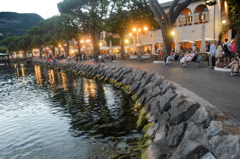 Promenáda podél jezera v Garda je typickým cílem pro večerní procházku