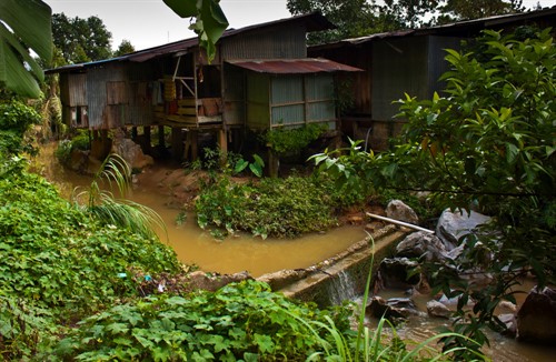 Zákoutí v chudinském slumu na krají džungle pod skalními útesy